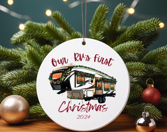 May include: White ceramic Christmas ornament with a drawing of an RV decorated for the holidays. The ornament has the text "Our RV's first Christmas 2024" in red script. The ornament hangs from a brown string.