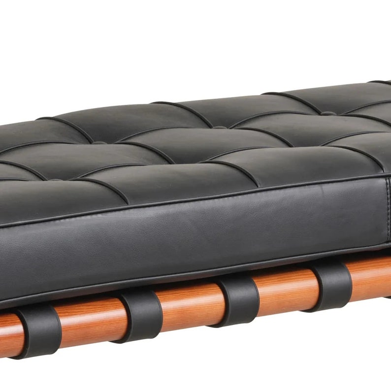 May include: A black leather bench with a tufted design and a wooden frame with black straps.