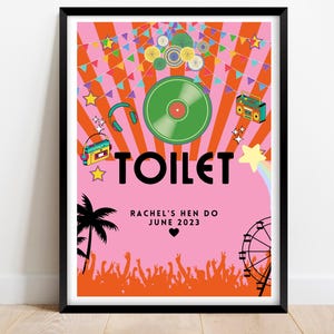 May include: A framed poster with a pink background and the word "TOILET" in large black letters. The poster features a retro music festival theme with a record, boombox, and text that reads "Rachel's Hen Do June 2023".