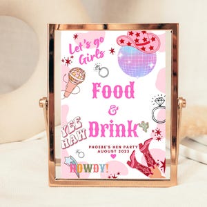 May include: A pink and white sign with the text "Let's go Girls", "Yee Haw", "Food & Drink", "Phoebe's Hen Party August 2023", and "Howdy!"  The sign also features a disco ball, a cowboy hat, a microphone, and a ring.