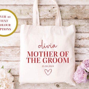 Puede incluir: Bolsa de tela blanca con texto rojo que dice "Olivia Madre del Novio 25.08.2024" con un pequeño corazón rojo.