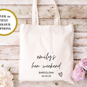 May include: White canvas tote bag with black text that reads "emily's hen weekend BARCELONA 10.10.22" and a small heart.