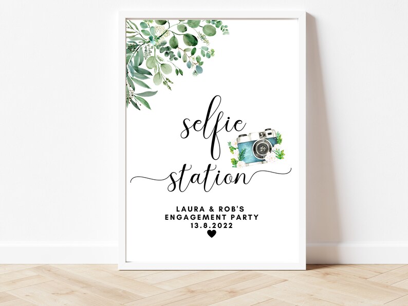 Puede incluir: Un cartel imprimible con una ilustraci&oacute;n de acuarela de vegetaci&oacute;n y una c&aacute;mara vintage. El texto dice "selfie station" con las palabras "Laura & Rob's Engagement Party 13.8.2022" debajo.