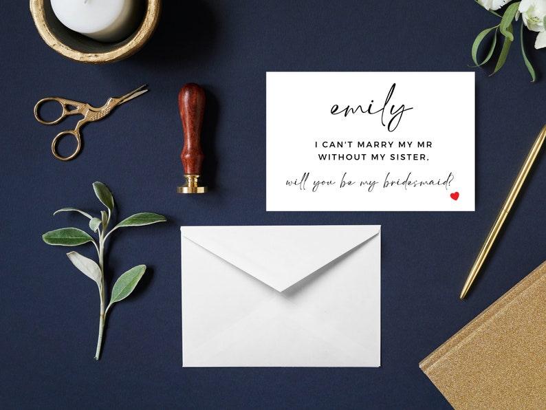 Op de afbeelding: Een witte kaart met zwarte tekst die "emily I CAN'T MARRY MY MR WITHOUT MY SISTER. will you be my bridesmaid?" zegt met een klein rood hartje.