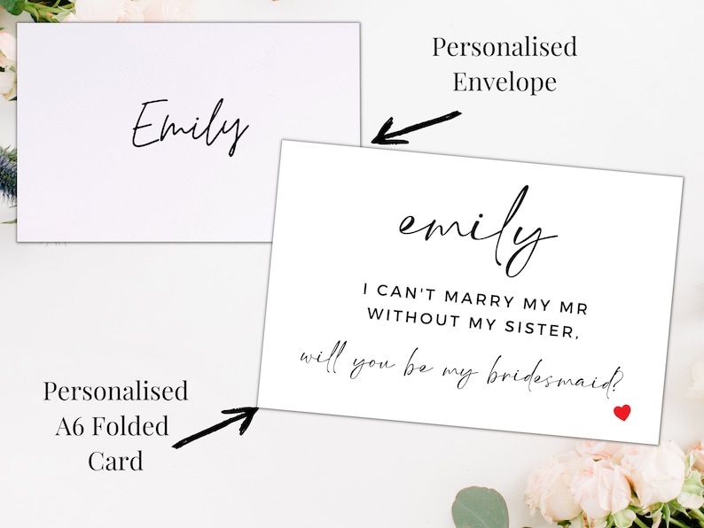 Op de afbeelding: Een witte gevouwen kaart met zwarte tekst die "emily I CAN'T MARRY MY MR WITHOUT MY SISTER, will you be my bridesmaid?" luidt, met een klein rood hart. De kaart is aan de voorkant geadresseerd aan "Emily".