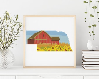 May include: A cross-stitch pattern of a red barn with a brown roof, surrounded by yellow sunflowers. The barn is set against a blue sky with white clouds.