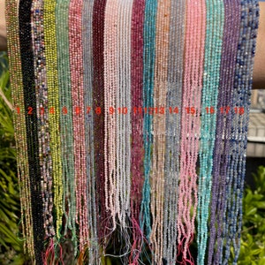 Peut inclure: Dix-huit brins de perles de pierres précieuses, chacun enfilé sur un fil fin. Les perles sont de différentes couleurs, notamment noir, vert, rose, rouge, blanc, bleu et gris. Les brins sont numérotés de 1 à 18.