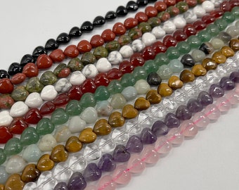 Puede incluir: Una colección de cuentas de piedras preciosas en forma de corazón en varios colores, incluyendo negro, rojo, verde, marrón, transparente, morado y rosa.