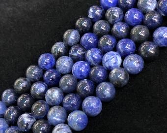 May include: A strand of blue and dark blue gemstone beads. The beads are round and smooth, and they have a natural, polished finish.