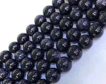 May include: A strand of dark blue gemstone beads with a sparkly, speckled finish. The beads are round and uniform in size.