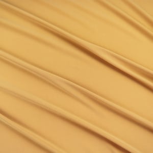 May include: A smooth, golden yellow fabric with soft, flowing folds. The fabric has a subtle sheen and a luxurious feel.