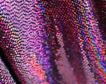 Puede incluir: Primer plano de una tela con un patrón texturizado de pequeñas lentejuelas iridiscentes en tonos rosa, morado y rojo.