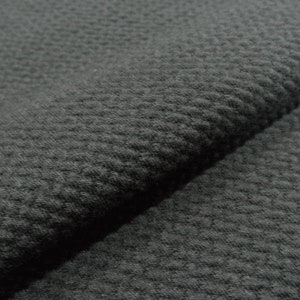 May include: Close-up of a dark gray textured fabric with a subtle diamond pattern. The fabric is soft and has a slightly raised texture.