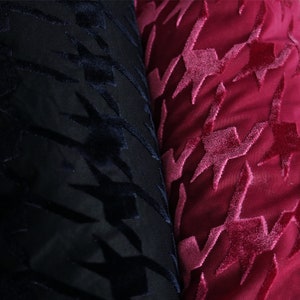 May include: Close-up of two fabric swatches with a houndstooth pattern. One swatch is black and the other is a deep burgundy red.