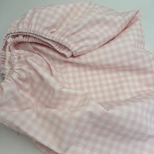 Puede incluir: Una sábana bajera de cuadros vichy rosa y blanco. La sábana está hecha de un tejido suave y transpirable, perfecta para añadir un toque de elegancia a cualquier dormitorio.