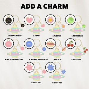 May include: A collection of keychains with various charms, including a heart, flower, tennis ball, hotdog, and cherries. Each keychain features a planet-shaped charm with pastel colors and the text "ADD A CHARM".