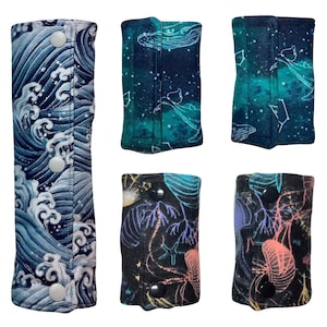 以下が含まれることがあります： 海のテーマのさまざまなプリントが施された、6つの異なるファブリック製のジッパーポーチ。ポーチはすべて同じサイズと形であり、ジッパーで閉じられます。プリントには、波、クジラ、クラゲ、星が含まれています。