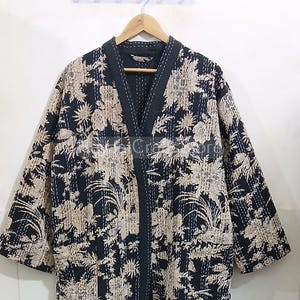 以下が含まれることがあります： Vネックと3/4袖の黒と白のフローラルプリントのキルトローブ