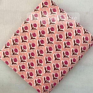 May include: Pink cotton fabric with a repeating pattern of pink flowers with brown stems. The fabric is ideal for quilting, sewing, and crafting.