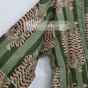 May include: Green and brown cotton kimono with a tiger print. The kimono has a long sleeve and a tie closure.