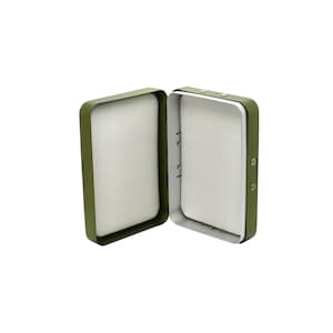 Może przedstawiać: Zielone metalowe pudełko na muchy wędkarskie z białym wnętrzem z pianki. Pudełko jest otwarte, a pokrywa jest uniesiona.