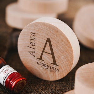 May include: A wooden round box with the name "Alexa" and the letter "A" engraved on it. The box also has the text "Groomsman 09.05.2012" engraved on it.