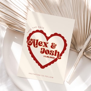 May include: A cream-coloured wedding invitation card featuring a red heart-shaped design and the names "Alex & Josh" in a retro font. The card also includes the date "14.02.2026" and the text "Save the Date" and "Invitation to Follow".