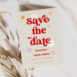 Beige save the date cards with red retro writing