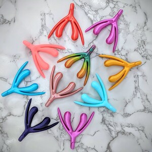 May include: Ten colorful plastic anatomical models of the female reproductive system. The models are arranged in a circle on a white marble surface.