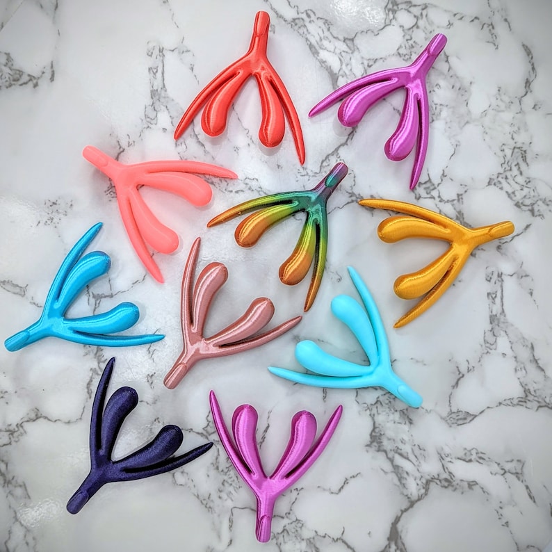 May include: Ten colorful plastic anatomical models of the female reproductive system. The models are arranged in a circle on a white marble surface.