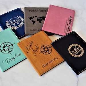 May include: Six passport holders with different designs. The holders are made of leather and have different colors, including blue, brown, pink, black, and green. The holders are personalized with names, initials, and compass designs.