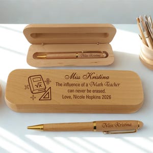 May include: A wooden pen and pencil case set with a matching pen. The pen case is engraved with the text "Miss Kristina" and "The influence of a Math Teacher can never be erased. Love, Nicole Hopkins 2026". The pen has gold accents.