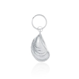 May include: A silver key ring with a detailed clam shell charm. The charm is a realistic depiction of a clam shell with a textured surface.