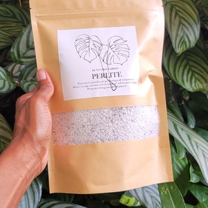 May include: A brown paper bag with a white label that says "SK NATURAL GARDEN PERLITE. Expanded material helps in preventing soil compaction. Helps drainage, aeration and eliminates soil for potted plants. Promotes strong root development."
