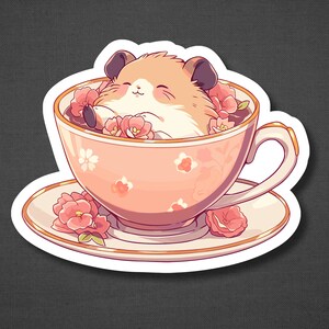 Puede incluir: Una taza de t&eacute; rosa con un patr&oacute;n floral blanco y rosa, llena de flores rosas y un peque&ntilde;o h&aacute;mster marr&oacute;n y blanco descansando dentro.