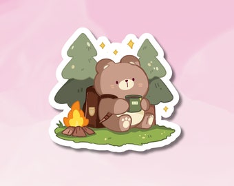 May include: A brown bear cartoon character sitting by a campfire with a green tree behind it. The bear is holding a cup of coffee and wearing a brown backpack.