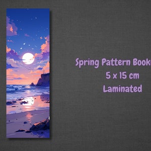 K&ouml;nnte beinhalten: Ein laminiertes Lesezeichen mit einer farbenfrohen Sonnenuntergangsszene mit Vollmond, Wolken und einem Strand mit felsigem Ufer. Das Lesezeichen ist 5 cm x 15 cm gro&szlig;.