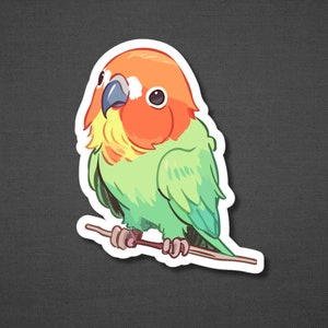 K&ouml;nnte beinhalten: Ein Aufkleber mit einem gr&uuml;n-orangen Liebesvogel, der auf einem Ast sitzt. Der Vogel hat eine gelbe Brust und einen leuchtend orangen Kopf.