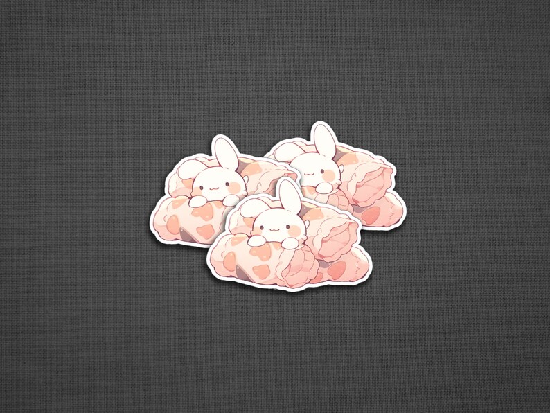 May include: Three white bunny stickers with pink and white blankets. The bunnies are peeking out from the blankets.