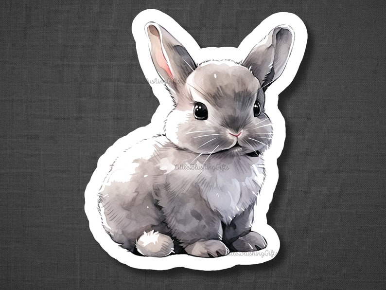 May include: A watercolour illustration of a grey bunny rabbit with white fur on its chest and belly. The bunny is sitting with its ears perked up and looking at the viewer.