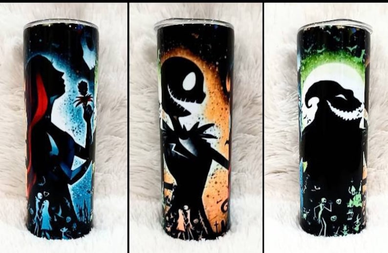 Puede incluir: Tres vasos de acero inoxidable con dise&ntilde;os envolventes con personajes de The Nightmare Before Christmas. Un vaso representa a Sally, otro a Jack Skellington y el tercero, Oogie Boogie, todos sobre fondos coloridos.