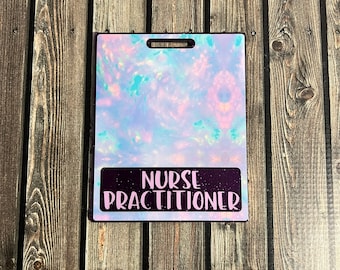 Puede incluir: Un porta credenciales iridiscente morado y rosa con una franja negra en la parte inferior que dice "NURSE PRACTITIONER" en letras rosas.