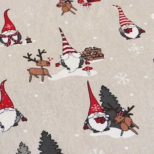 Könnte beinhalten: Ein beiger Stoff mit einem sich wiederholenden Muster aus Weihnachtszwergen, Rentieren, Schneeflocken und Bäumen. Die Zwerge tragen rote Hüte und Schals. Die Rentiere haben Geweihe und sind braun. Die Bäume sind dunkelgrün.