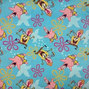 May include: A light blue fabric with a repeating pattern of cartoon characters SpongeBob SquarePants and Patrick Star. The design includes yellow and pink starfish and pink and yellow flower shapes.