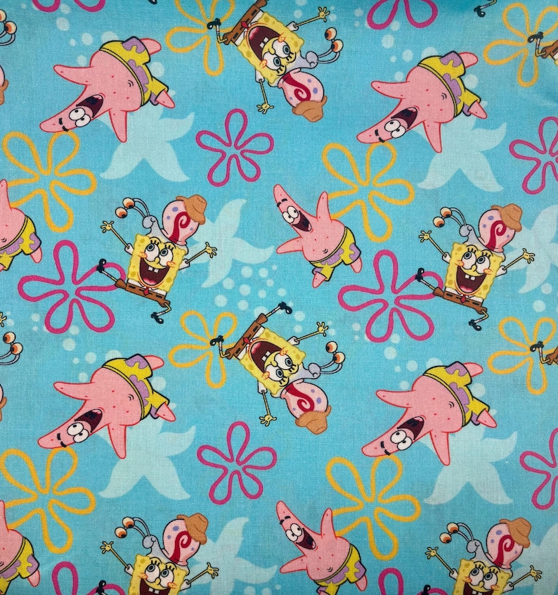 May include: A light blue fabric with a repeating pattern of cartoon characters SpongeBob SquarePants and Patrick Star. The design includes yellow and pink starfish and pink and yellow flower shapes.