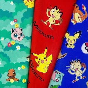 May include: Close-up of three colorful fabric panels featuring cartoon characters. The green panel has a floral and cloud pattern with Jigglypuff and Charmander. The red panel has Pikachu and Meowth with the text "Pikachu" and "Meowth". The blue panel has Meowth, Pikachu, and a Poke Ball.