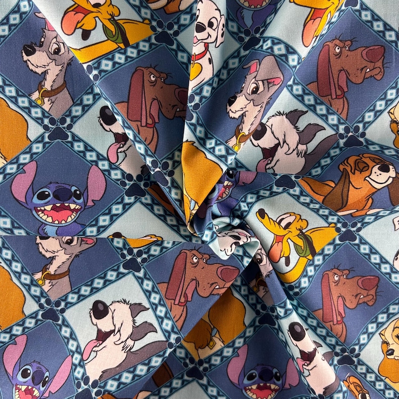 May include: Light blue fabric featuring a repeating pattern of cartoon dogs and Stitch from Lilo & Stitch. The dogs are in various poses, set within diamond-shaped frames with a darker blue border. The fabric has a slight sheen.