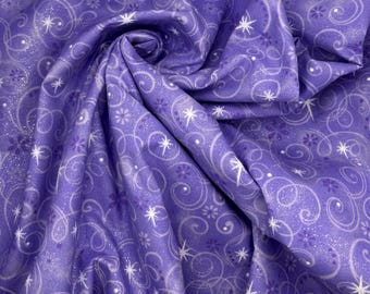 May include: Close-up of a folded fabric. The fabric is purple with a repeating pattern of white swirls, stars, and floral shapes. The fabric has a slight sheen, and the design is evenly distributed across the surface.