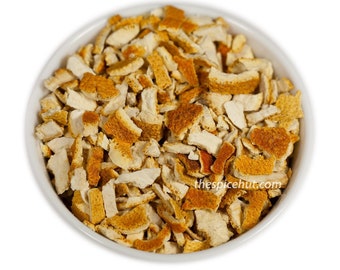May include: A white bowl filled with dried orange peel pieces. The pieces are a mix of light beige and orange, with a rough, textured appearance. The image is taken from a top-down perspective against a white background. The text "thespicehut.com" is visible.