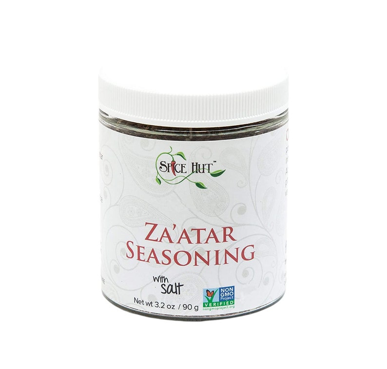 Peut inclure: Un pot blanc avec une &eacute;tiquette verte et rouge qui indique "SPICE HUT" et "ZA'ATAR SEASONING with Salt". Le pot contient 90 grammes (3,2 onces) d'assaisonnement au za'atar et porte le logo "Non-GMO Project Verified".